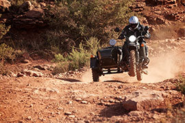 Brian McVickers riding a motorcycle on a dusty road