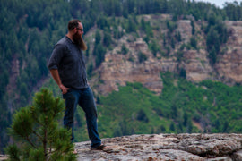 Chris Ramm on a rock looking right