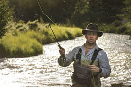 Jon Solberg in a river holding a fishing pole